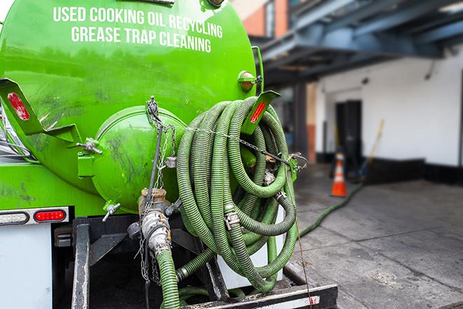 a grease trap being pumped by a sanitation technician in New Rochelle